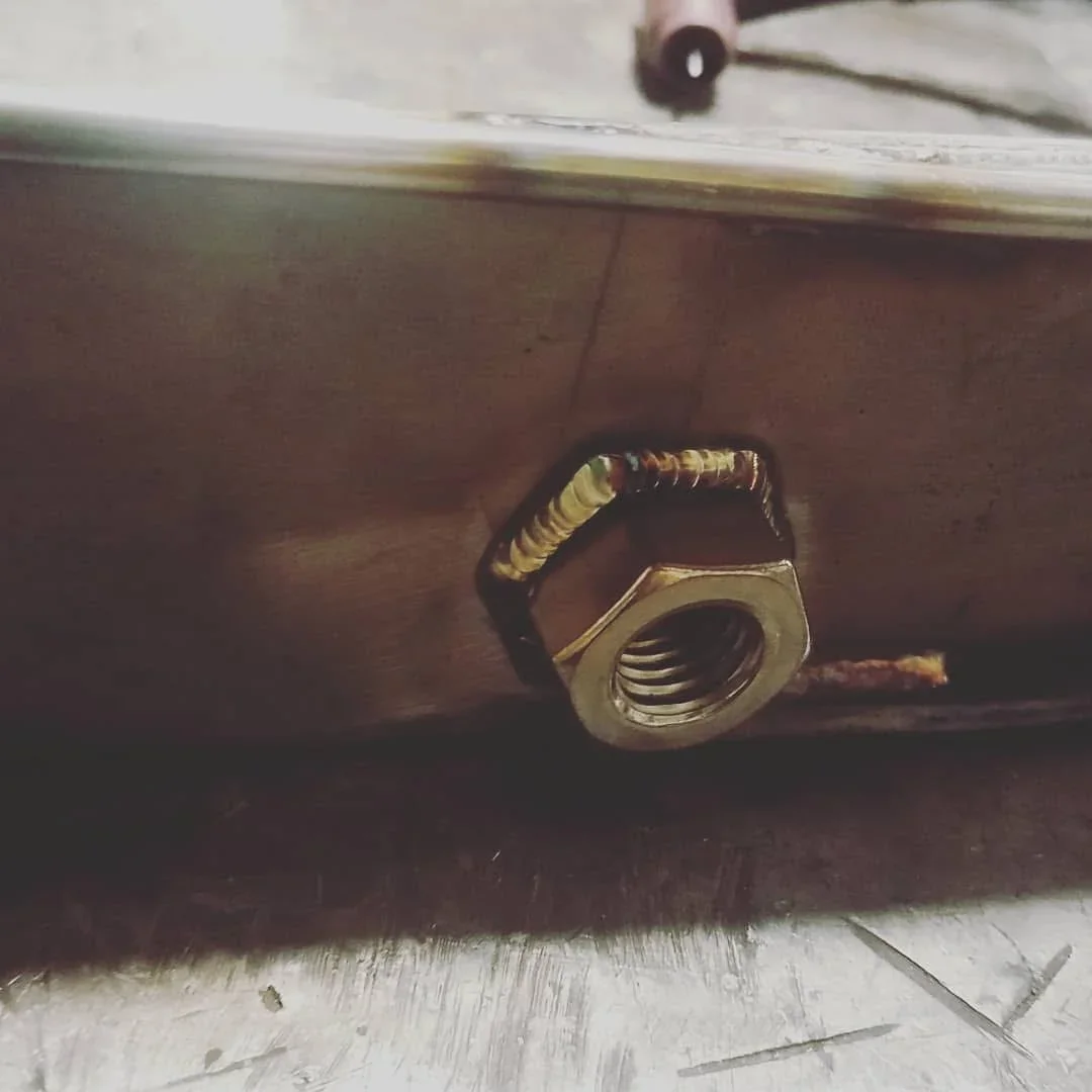 Brass hex nut on corroded threaded rod with oxidation and rust buildup
