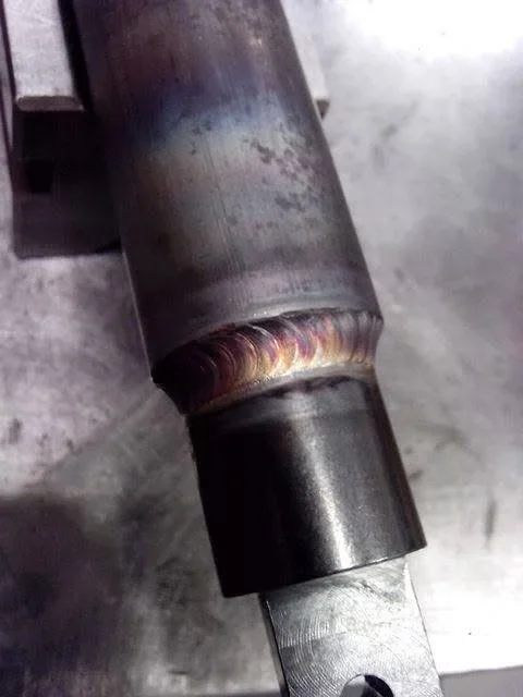 MIG welded pipe joint with golden bead on steel cylindrical tubing