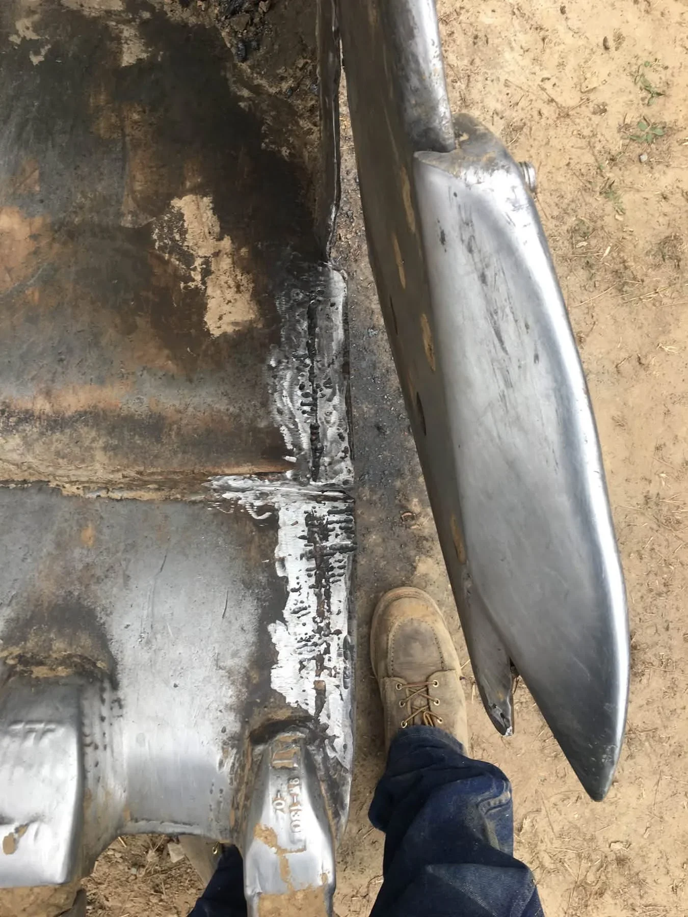 Welded steel pipe joint repair showing fresh weld bead on corroded pipe section