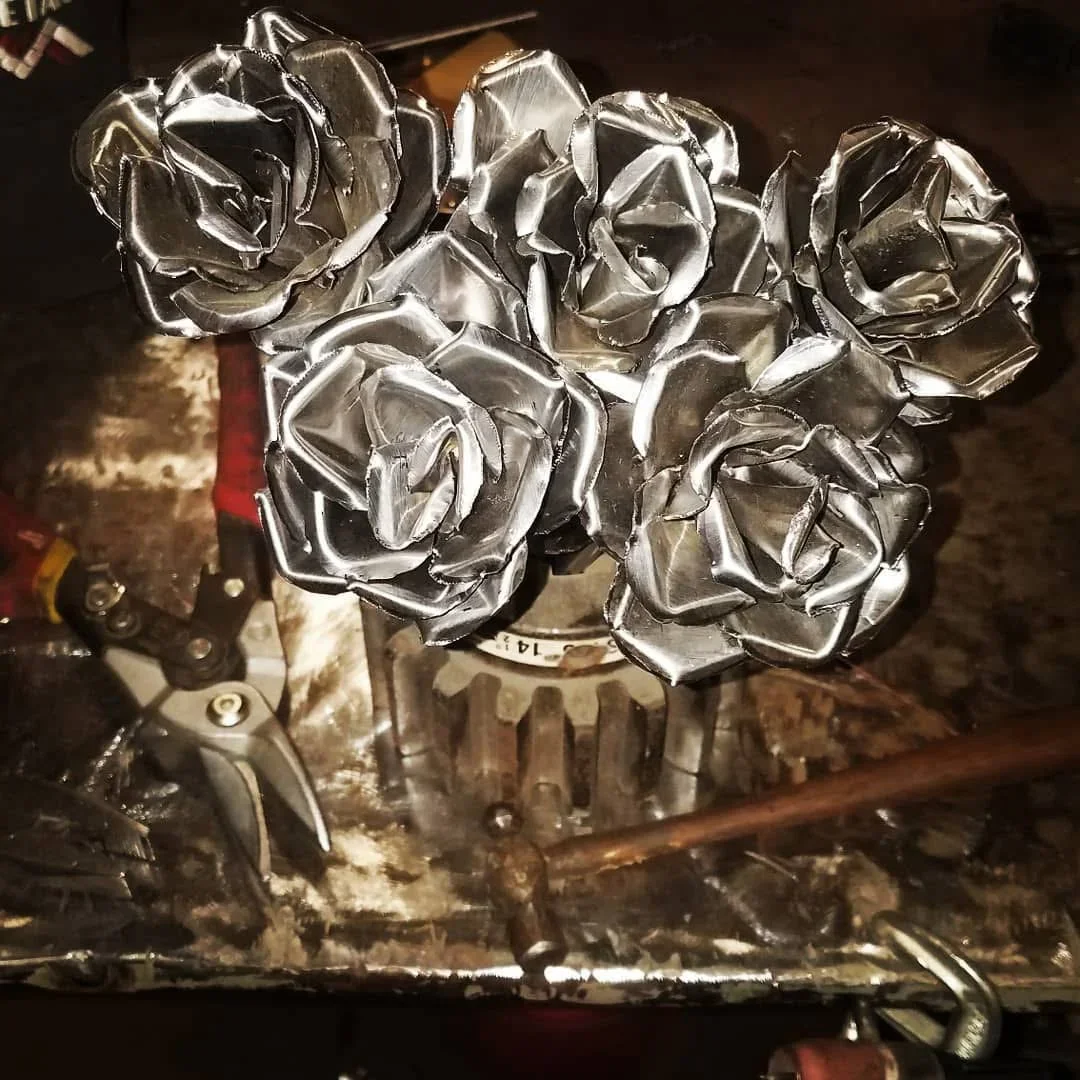 Seven polished steel roses with detailed petal work, welded and shaped metal flowers