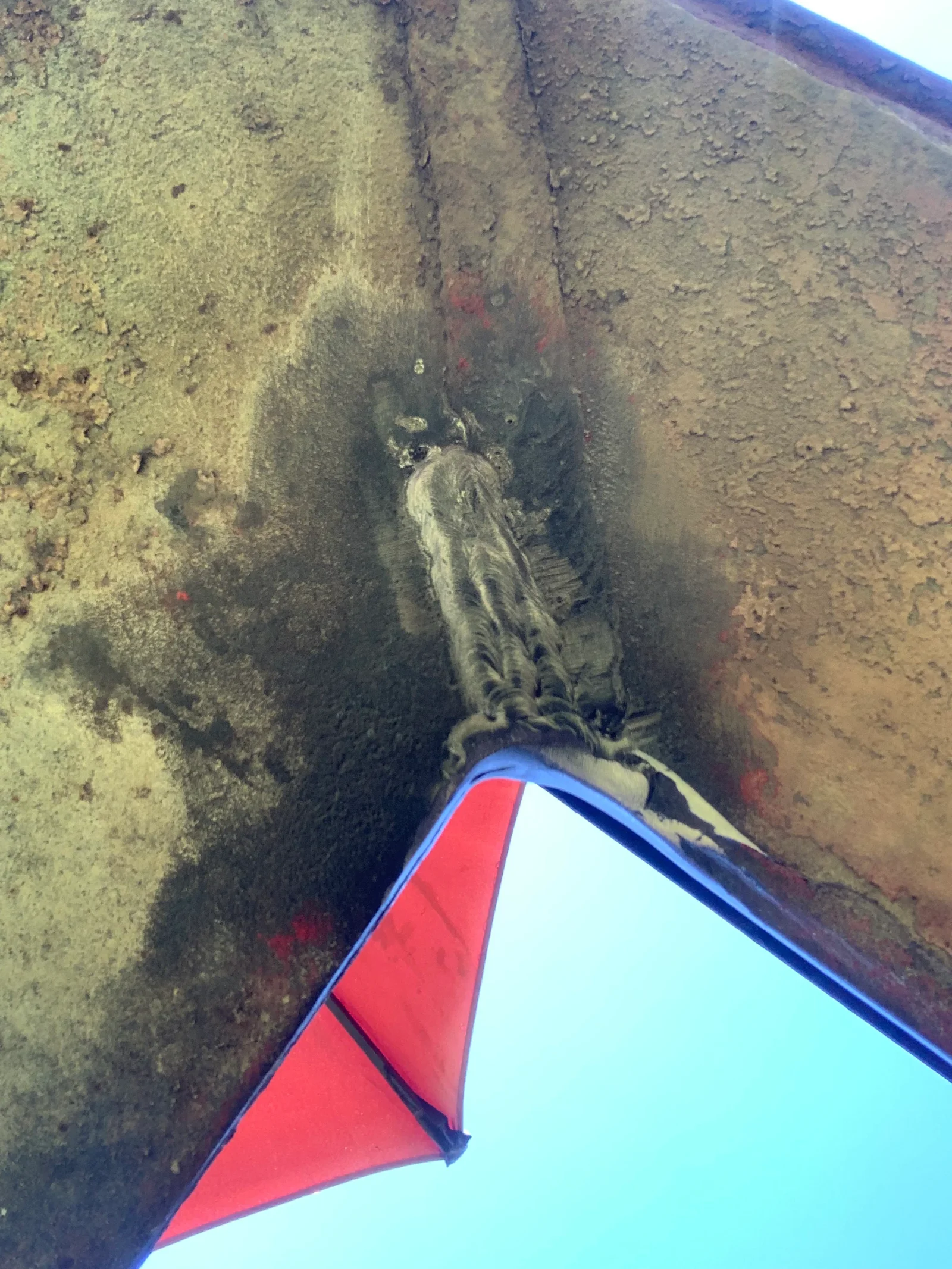 Corroded subsea pipeline with heavy rust and sediment buildup, ROV inspection view