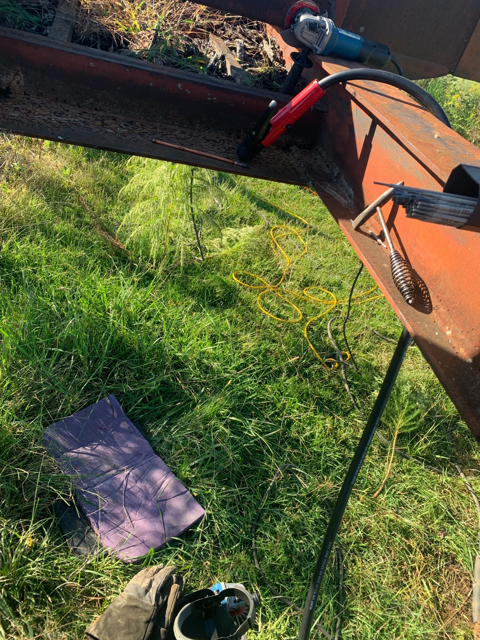 Orange gutter cleaning machine with debris hopper and powered auger system during service